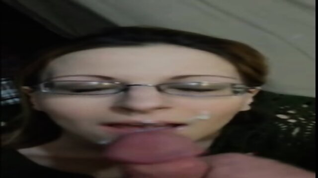 Une femme amateur portant des lunettes recoit une ejaculation salissante dans la bouche et le visage