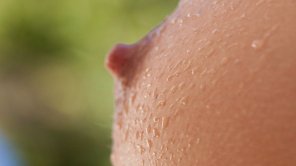 Water droplets on a single boob with an erect nipple