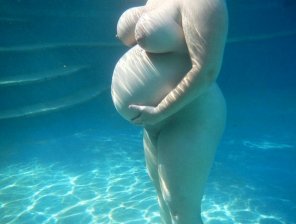 Busty pregnant babe floating underwater