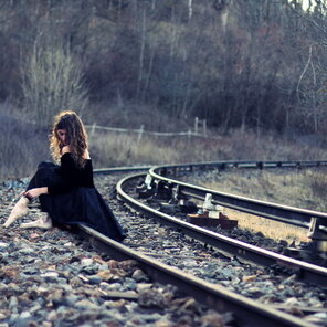 zdjęcie amatorskie Girl-In-Black-Dress-Sitting-On-Railways-2048x2048