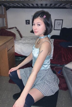 Adorable asian college freshman posing in a schoolgirl skirt with black thigh highs