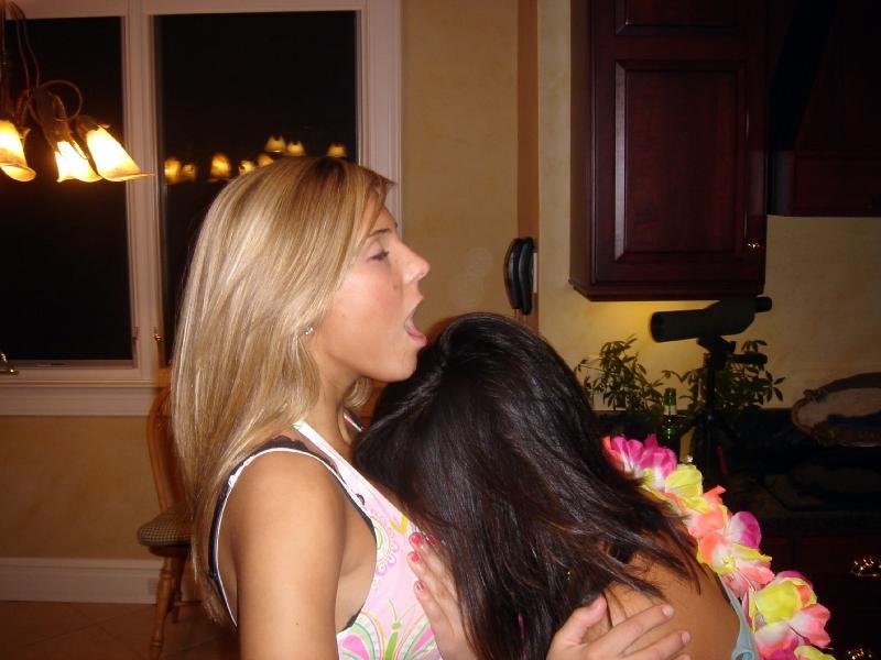 Burying her face in the blonde's cleavage