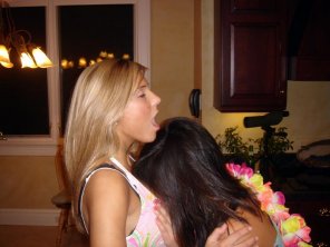 Burying her face in the blonde's cleavage