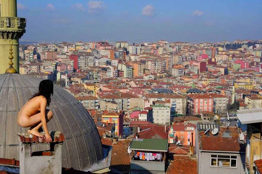 High atop Istanbul, Turkey, Batwoman scans the cityscape for the thief who stole her clothes