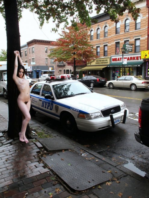 I love how she's posing beside a cop and across from the Meat Market.