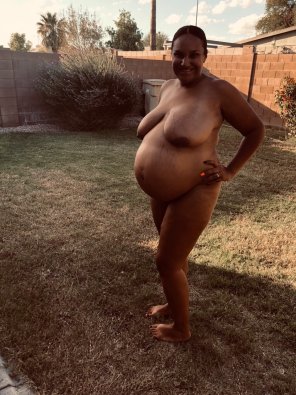 Beautiful pregnant woman going nude in her backyard
