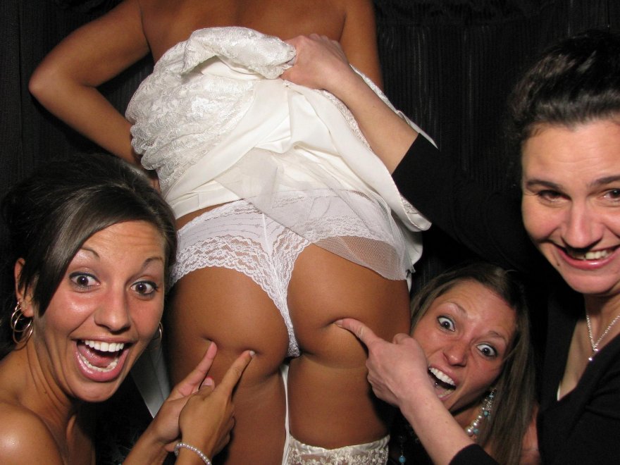 Bride flashing her thong in a photobooth with her bridesmaids