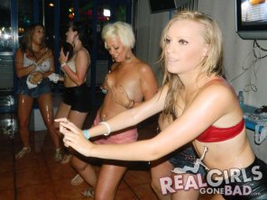 zdjęcie amatorskie Girl smiles as she covers her boobs during a competition in a bar